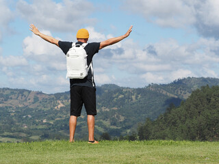 Excited man with backpack feels triumph outdoor in mountains. 