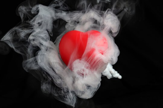 Red love hart flowing flying though white fog smoke mist on black background