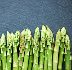 Closeup, asparagus or vegetables in kitchen for food or meal prep for salad, green ingredients or dinner. Home, background or catering with healthy nutrition for vegan diet, lunch or organic produce