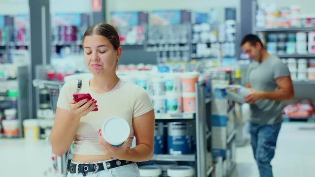 Female shopper scanning a QR code using a mobile phone in a hardware store. High quality 4k footage