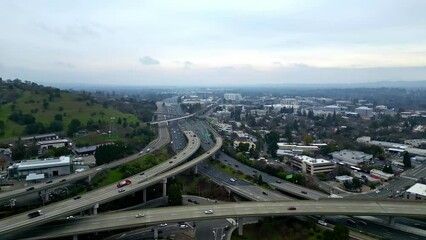 Aerial drone fly above highway roundabout intersection, walnut creek california skyline city town in American hillside