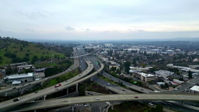Aerial drone fly above highway roundabout intersection, walnut creek california skyline city town in American hillside