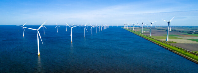 A picturesque scene of numerous windmills scattered across a vast body of water ocean