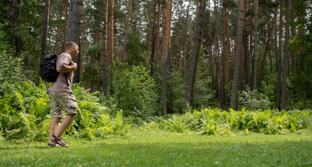 A man hiking in the summer forest 