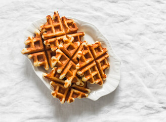 Cozy coffee break - cappuccino and waffles with condensed milk on a round wooden table