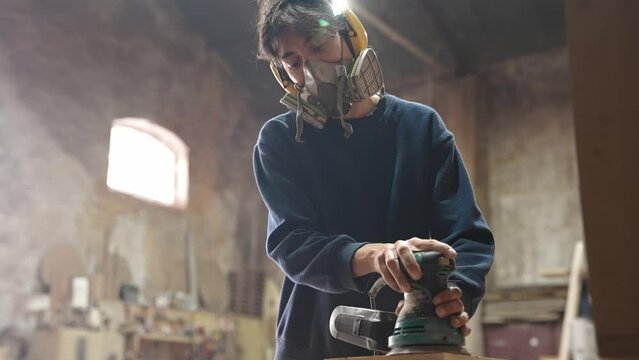 Woman carpenter sanding wood block. Feminist girl process timber bar. Male carpentry work skill. Female joiner woodwork. Feminism worker. Person use sander tool. Diy master class workshop. Job project