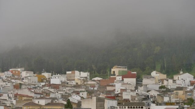humble houses on the side of a mountain surrounded by fog