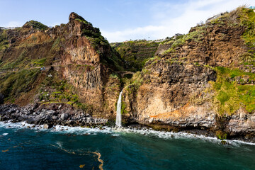 Fototapeta na wymiar Waterfall fall into Atlantic Ocean in Madeira Island, Portugal. Aerial Drone view