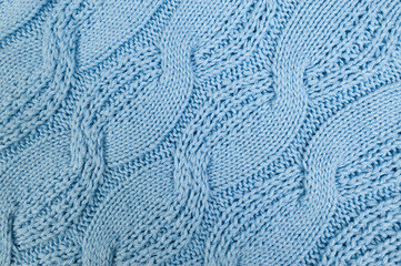 Blue knitted fabric background. Knitted braids texture. 