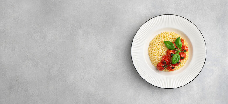 Pasta ptitim, Israeli couscous, in a white plate, top view, copy space