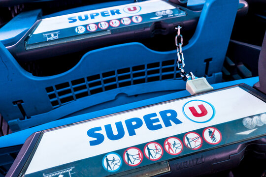 le logo et le nom de la chaine de distribution et de supermarche Super U sur les poignees des chariots de course