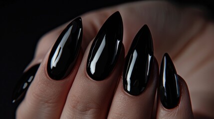 Close-up of black glossy stiletto nails.