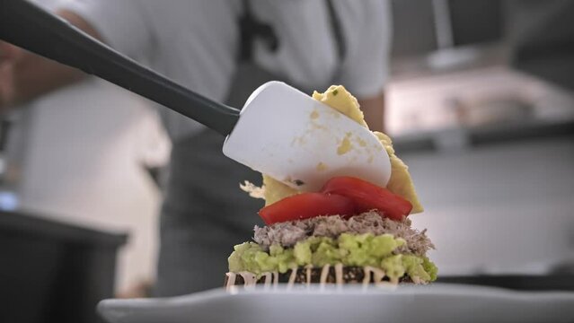 Male head chef prepare tasty fresh bruschetta dish close up. Man cook meal restaurant kitchen. Young adult person work cafe cuisine. Guy make diet lunch food. Culinary worker job. Cookery staff recipe