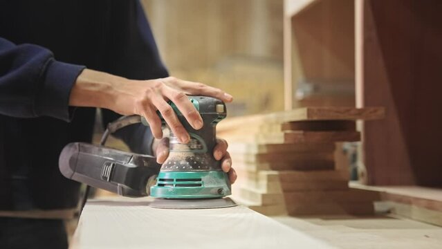 Woman carpenter sanding wood block. Feminist girl process timber bar. Male carpentry work skill. Female joiner woodwork. Feminism worker. Person use sander tool. Diy master class workshop. Job project
