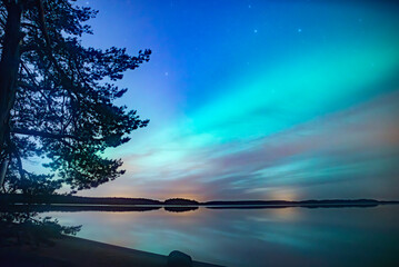 Northern lights dancing over calm lake in north of Sweden - obrazy, fototapety, plakaty