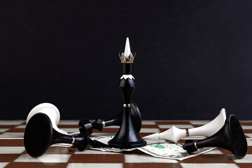 Black chess piece on a chessboard with dollar bills. Business concept. Game, strategy, wisdom,...