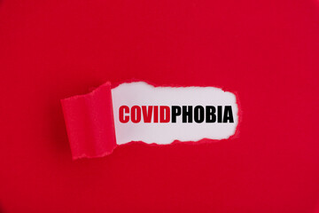 The text COVID PHOBIA appearing behind torn red paper.