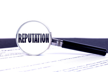 Magnifying glass with text concept word REPUTATION on a dark table and a light background.