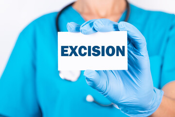 A doctor in blue medical uniform holds a card with the name of the diagnosis, the word EXCISION. Medical concept.