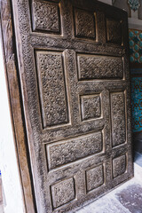 An ancient wooden door with patterns and ornaments in the ancient city of Khiva in Uzbekistan, wood carving
