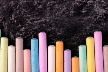 Closeup of blackboard with pieces of coloured crayons
