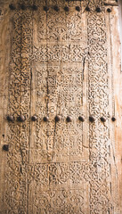 An ancient wooden door with patterns and ornaments in the ancient city of Khiva in Uzbekistan, wood carving