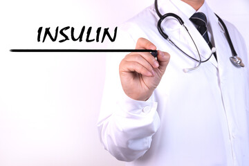 A doctor in medical clothing writes a diagnosis, text INSULIN with hand holding a marker. Medical concept.