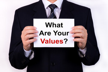 Businessman holds a tablet with the text WHAT ARE YOUR VALUES. Business concept