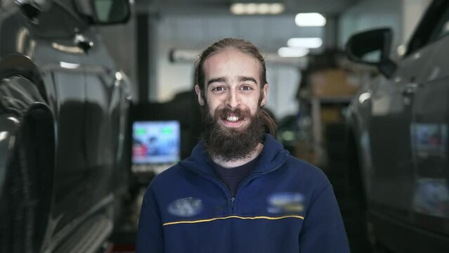 Technician work car service. Auto mechanic portrait. Cute smile engineer look at camera closeup. Man change tyre cover. Guy fix wheel at tire workshop. Happy worker repair. Repairman face close up.