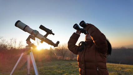 Amateur astronomer observing skies with a telescope and binoculars.
