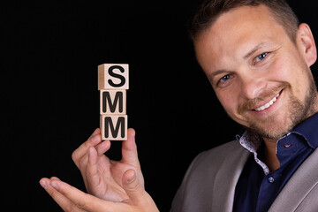 Businessman made the word SMM with wooden building blocks.