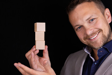 Closeup of businessman making a pyramid with empty wooden cubes. The concept of business hierarchy...