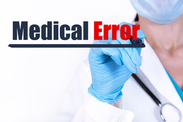 MEDICAL ERROR text is written with a marker held by a doctor with a stethoscope. Medical concept.