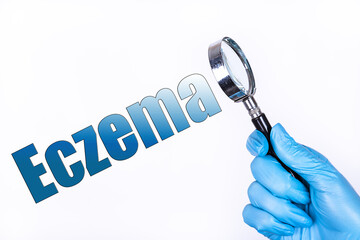 A hand in a blue medical glove holds a magnifying glass and points to the text Eczema. Medical...