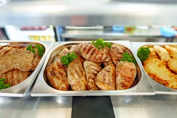 Tuinposter Grilled Chicken Breasts and Pork Cutlets Served in a Buffet Setting © fotofabrika