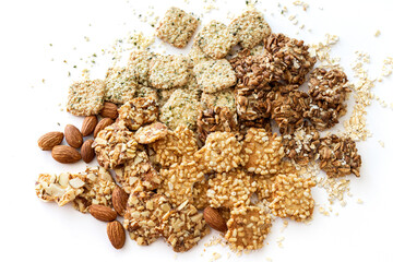 Baked snack made of tofu, brown rice, hemp seeds, almonds, and grains on a white background, top...
