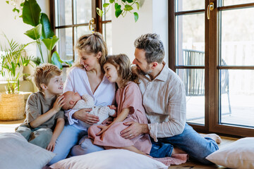Portrait of nuclear family with newborn baby. Perfect moment. Strong family, bonding, parents' unconditional love for their children.