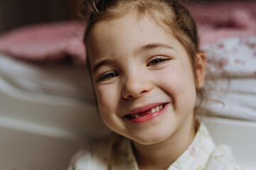 Portrait of cute girl smiling with gap-toothed grin, missing her baby teeth.