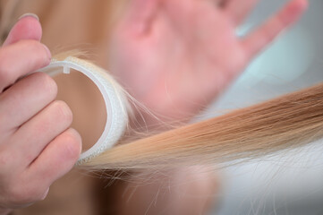 Close up of a hairdresser using a hair roller to create bangs or curly hair