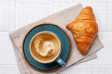 Cappuccino coffee and fresh croissant