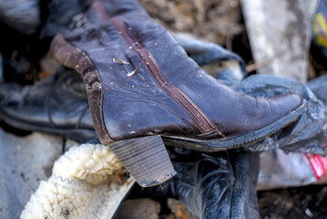 Women's leather boots thrown into a landfill