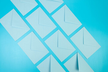 Top view of light blue envelopes on blue background. Post flat lay. Copy space.