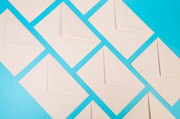 Top view of light pink envelopes on blue background. Post flat lay. Copy space.