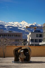 Modern sculpture among a rock garden in downtown Vaduz, Liechtenstein with the stunning alps visible in the distance