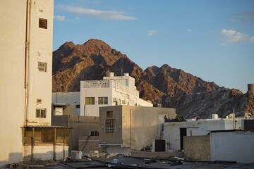 View of the peaks of the Hajar mountains in the background of a residential neighborhood in Muscat, Oman