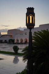 Arabian lamp and reflective courtyard on the grounds of the Royal Opera House Muscat at sunset in Muscat, Oman