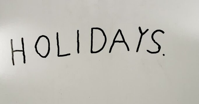 Holidays lettering created with black marker on white board. 4K Stop motion animation.
