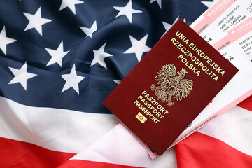Naklejka premium Poland passport with airline tickets on American US flag close up. Tourism and travel concept