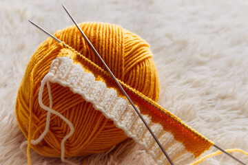 Yellow knitting yarn and knitting needles. Knitwear fashion. Wool socks and needles. Knitting hobby. Handcraft clothing. Needlework concept. Wool knitted socks. Homemade crochet footwear. - 779469561