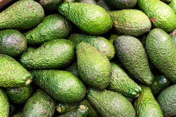 Avocado in the supermarket. Green ripe avocado background on the farm. Fruit and vegetable...